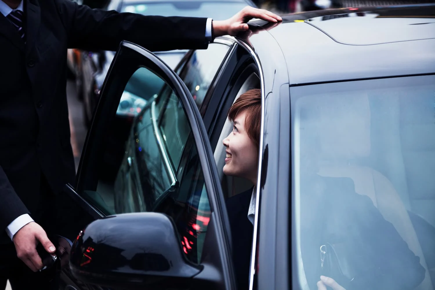 Chauffeur holding a car door for a passenger